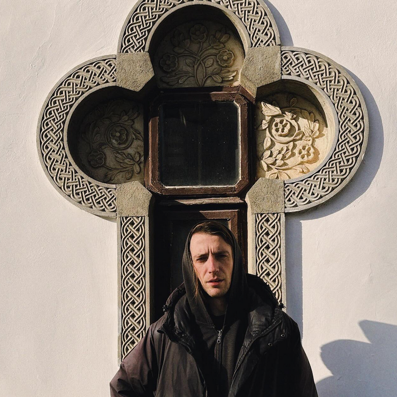 Zach Rowden standing in front of a cross
